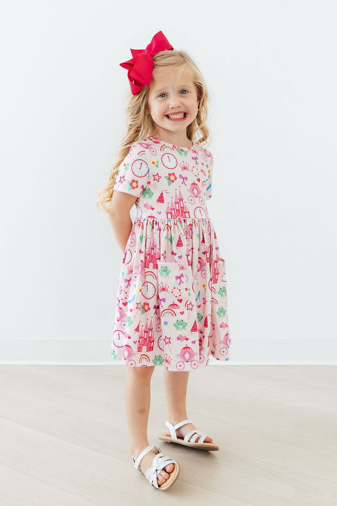 a girl wearing a dress and a red bow