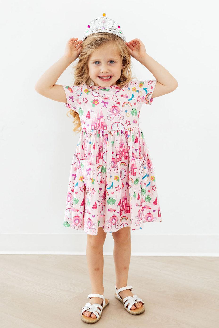 a girl in a dress with her hands on her head