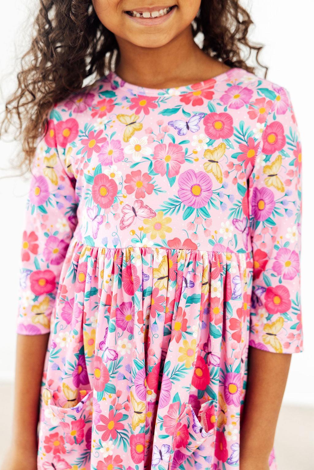a girl wearing a pink dress with flowers