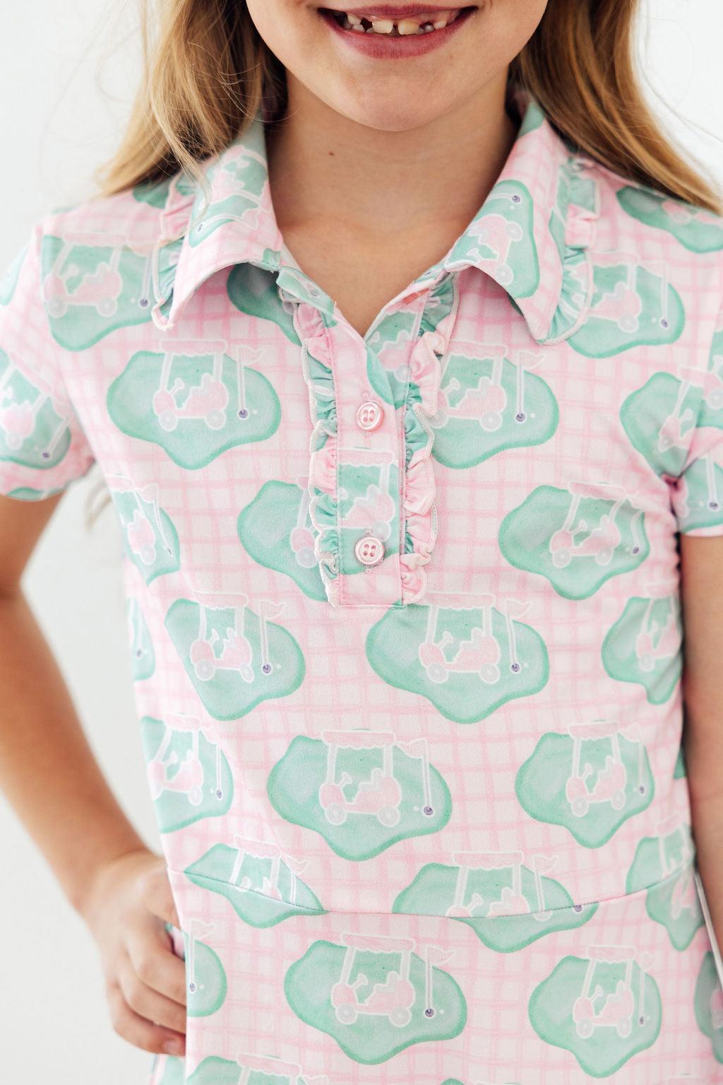 a girl wearing a pink and green shirt