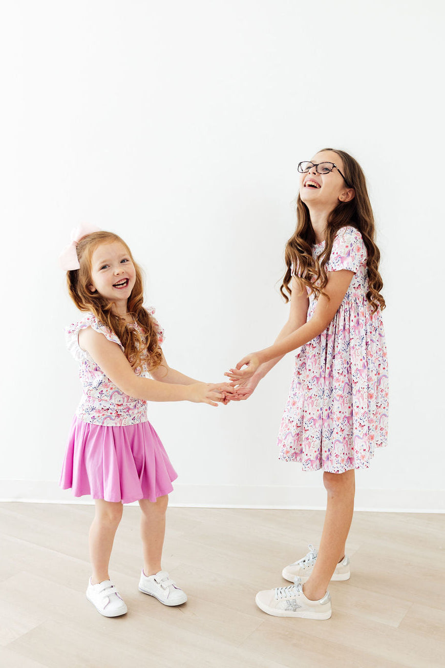 two girls holding hands and laughing