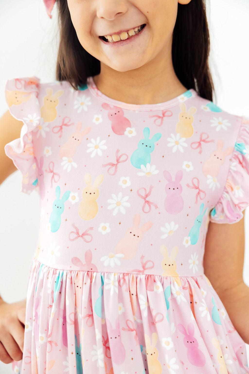 a girl wearing a pink dress with bunny designs