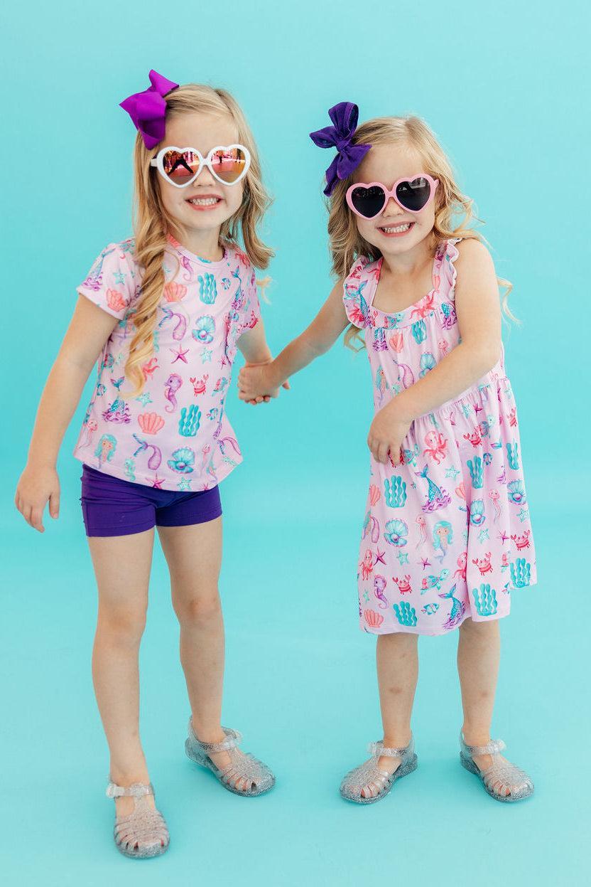 two girls holding hands and smiling