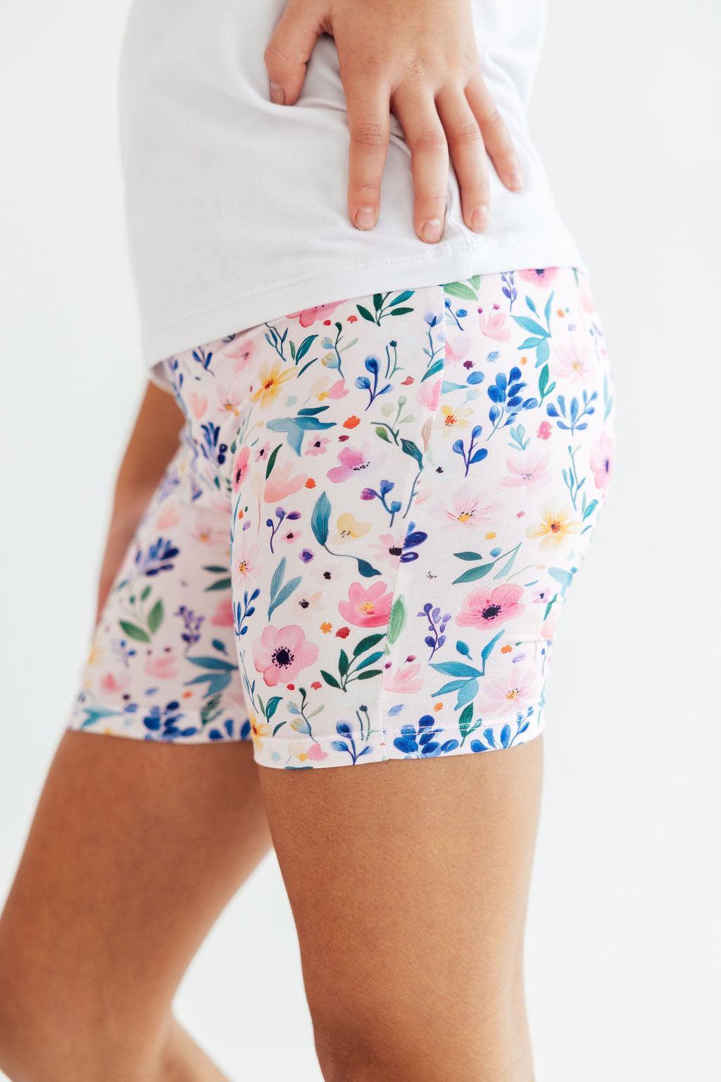 a person wearing shorts with flowers on them