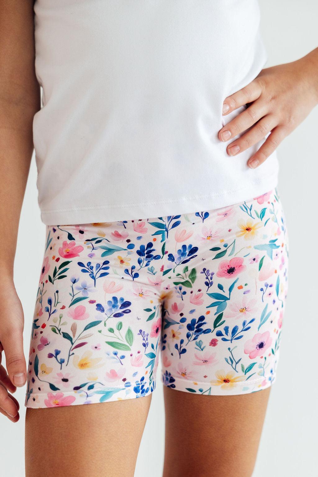 a person wearing shorts with flowers on them