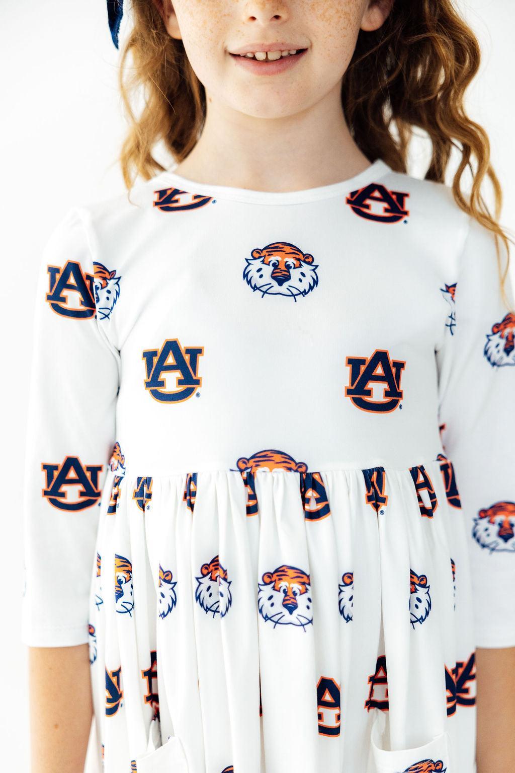 a girl wearing a white dress with tiger designs