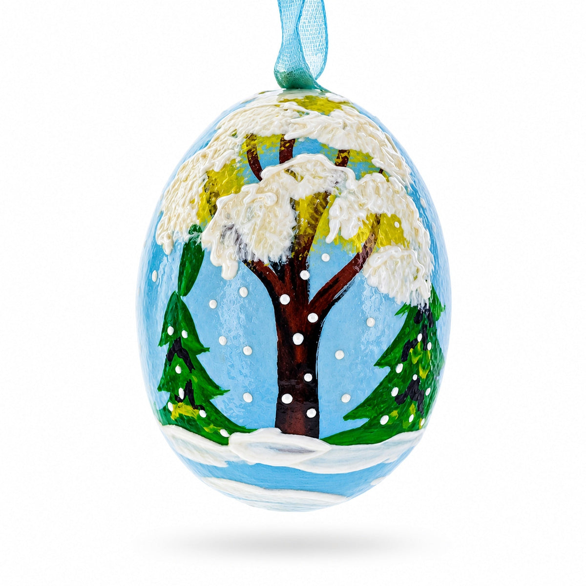 a painted egg with trees and snow on it