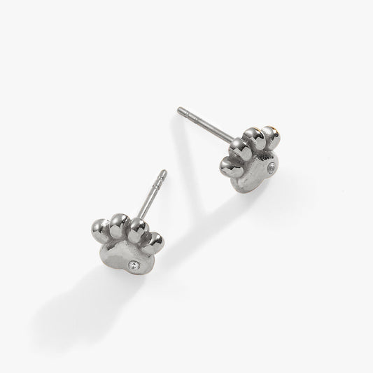 a pair of silver earrings with a paw print