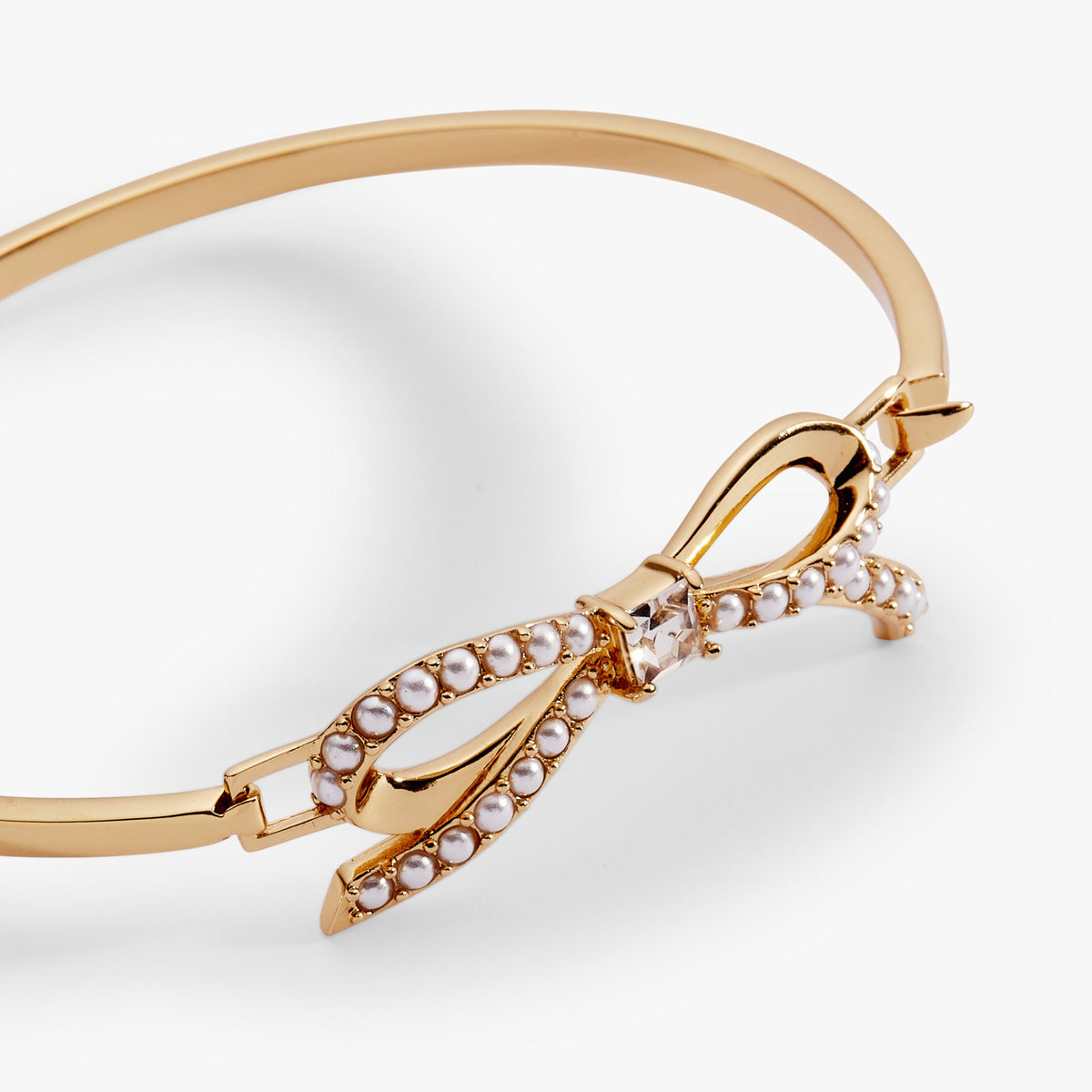 a gold bracelet with pearls and a bow