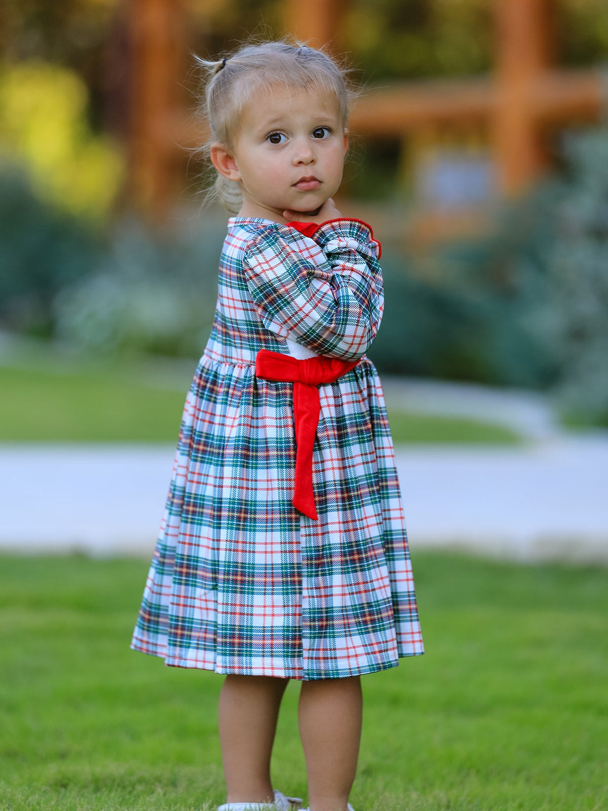 a little girl standing in a grass field