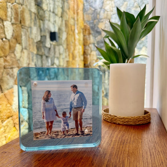 a glass frame with a picture of a family on a table
