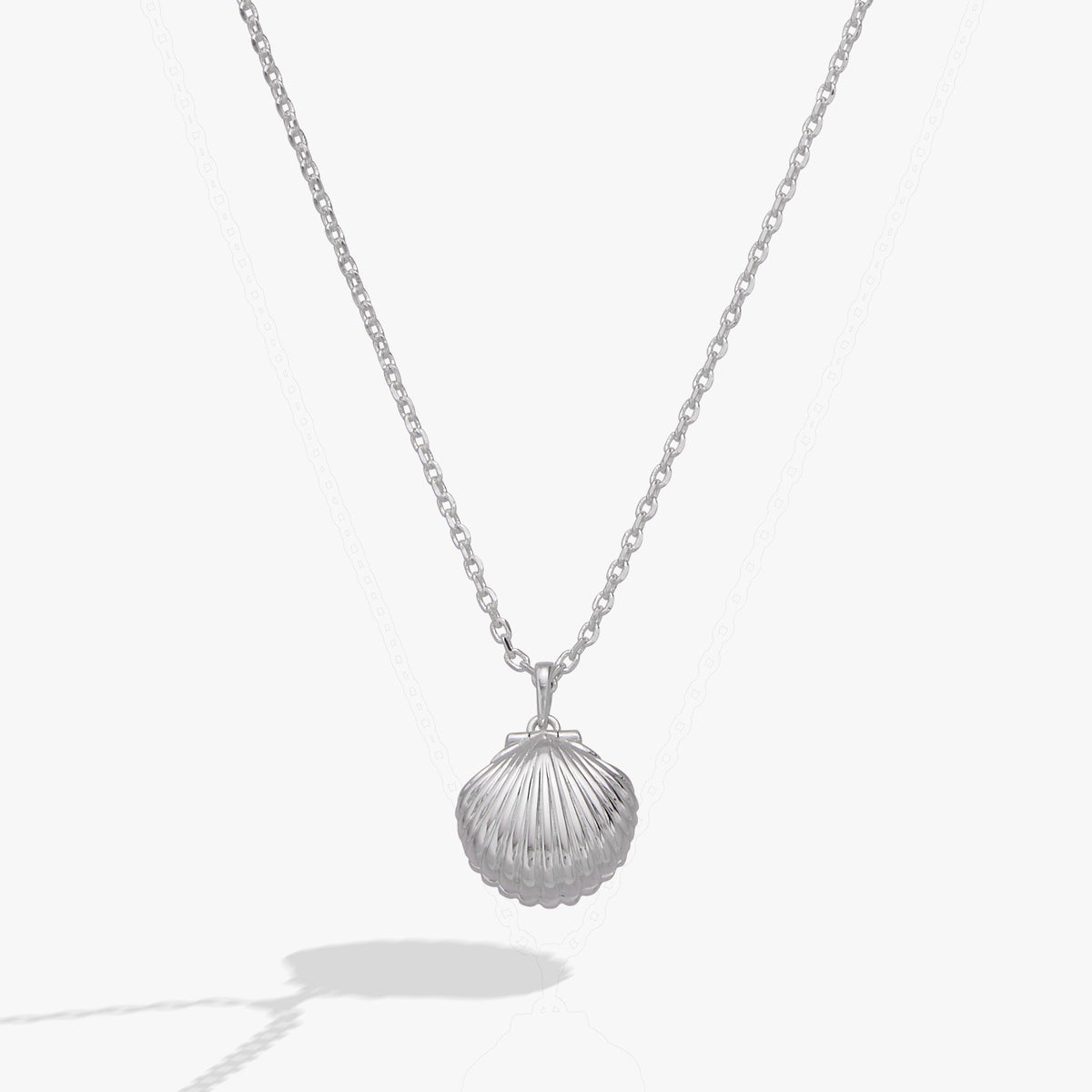 a silver necklace with a shell pendant