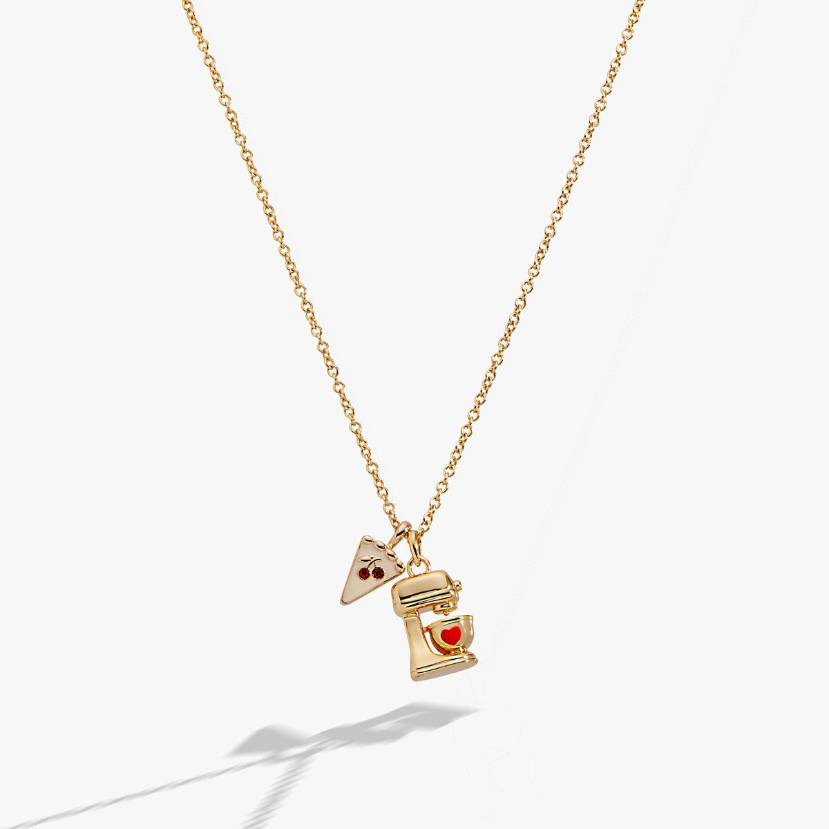 a gold necklace with a small piece of food on it
