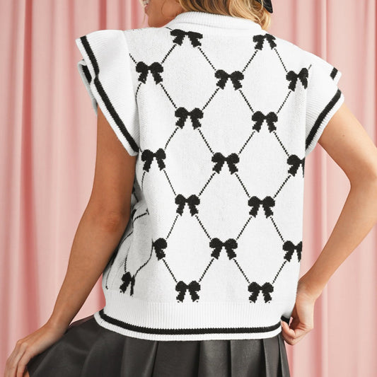 The Merry Hare white knit vest with black bow pattern, zipped collar, and ruffled cap sleeves.