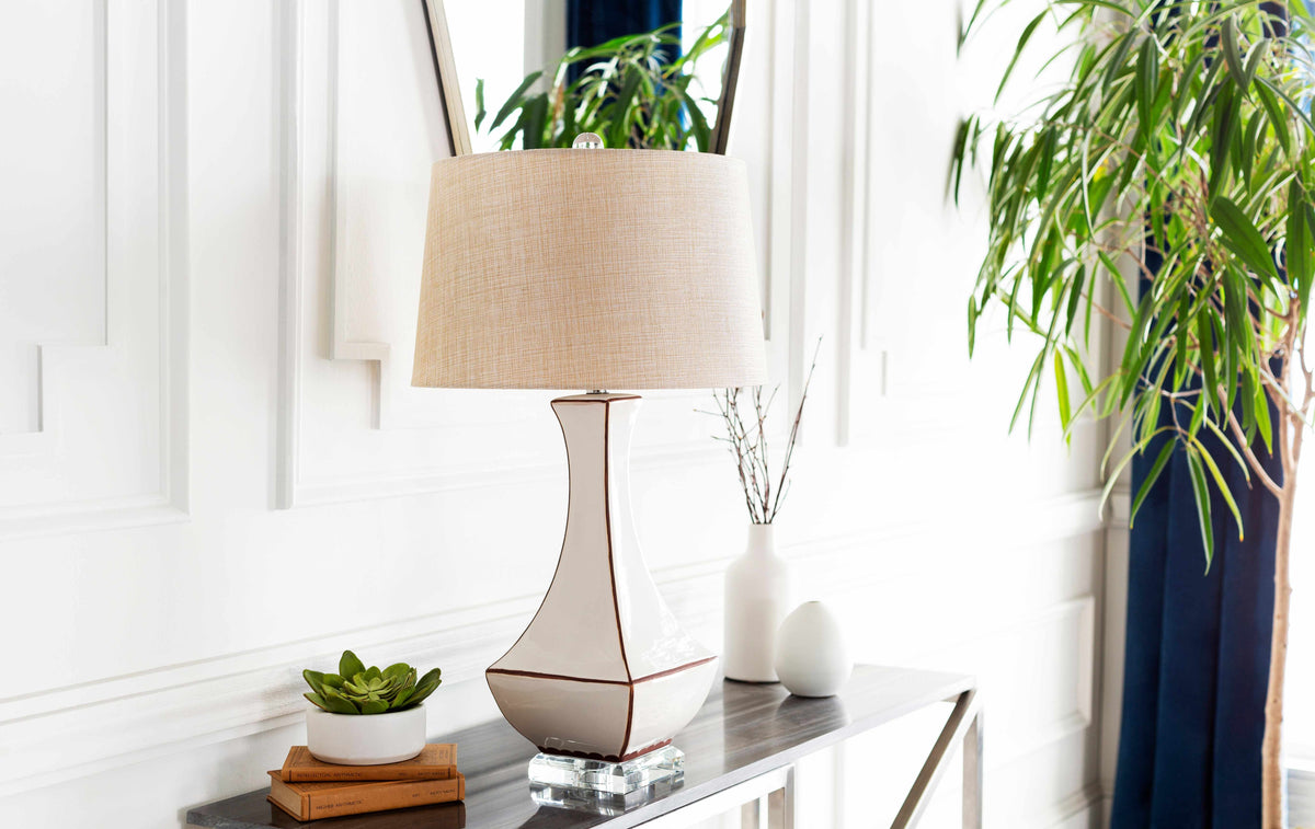 a table with a lamp and a plant on it
